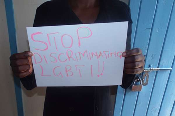 Man holds sign saying Stop discriminating LGBTI
